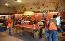 People playing pool in a cozy room.