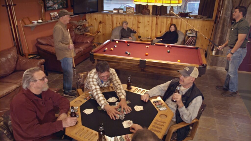 Photo of patrons enjoying billards and poker in the gaming room of Ringnecks Lodge.