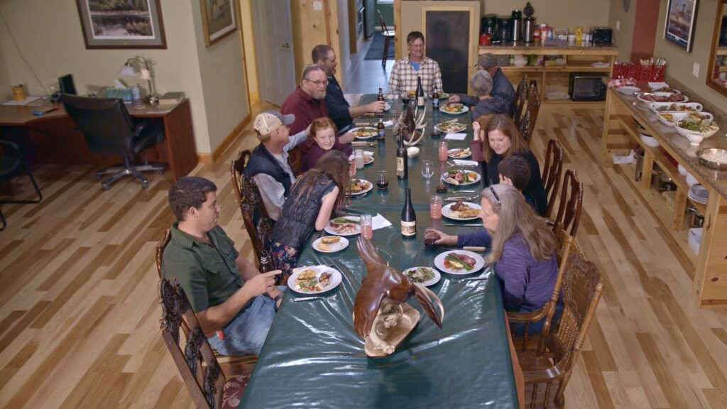 Photo of family eating at Ringnecks Lodge dining table in the dining hall of hunting lodge