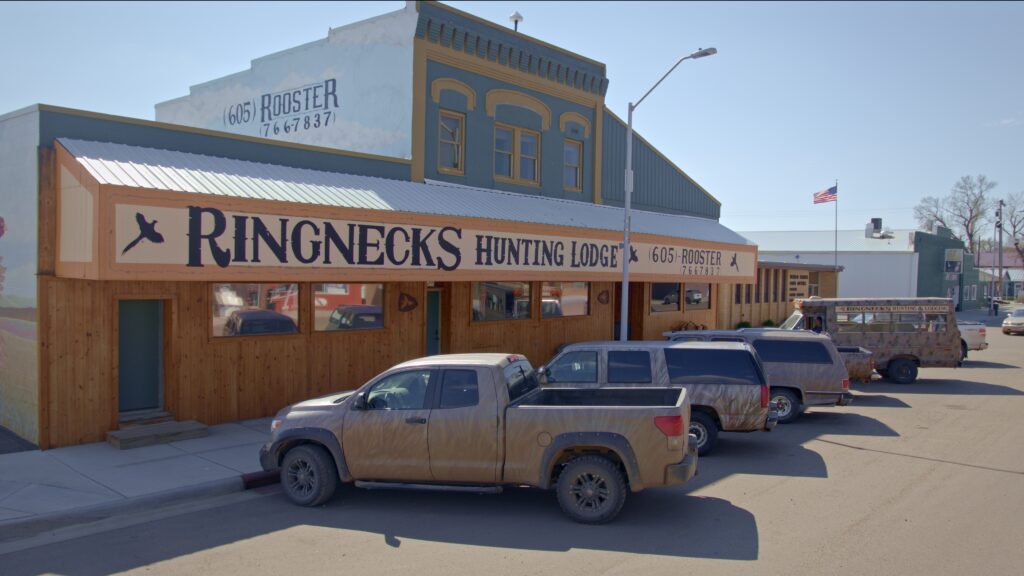 Photo of vehicles parked in front of Ringnecks Lodge on Main Street, Presho, SD.
