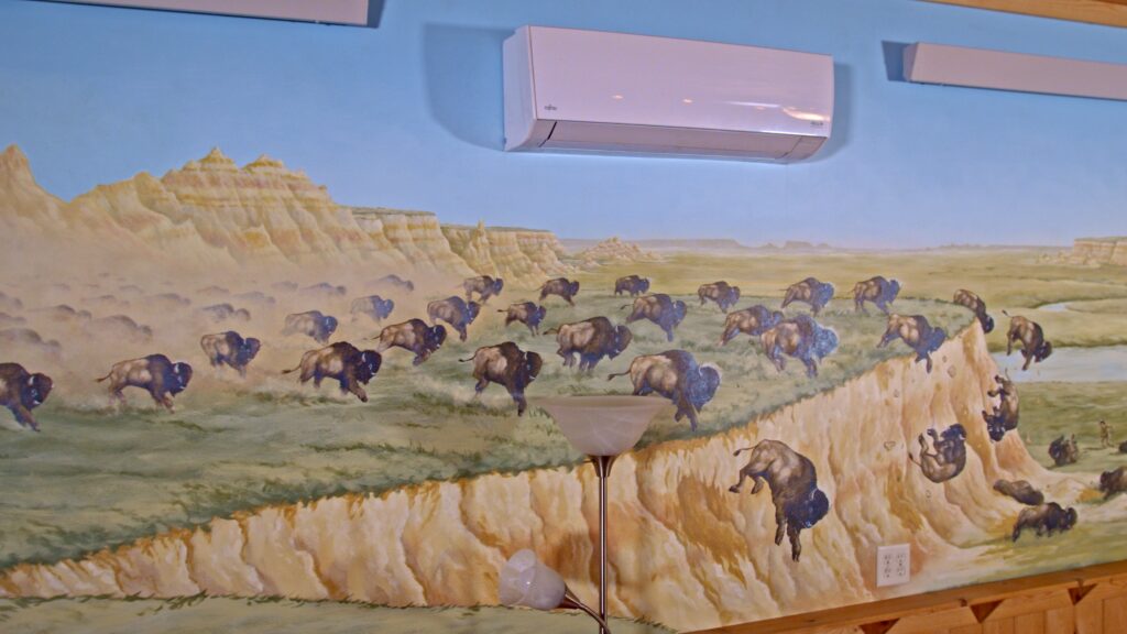 Native American mural painting of Bison falling off cliff