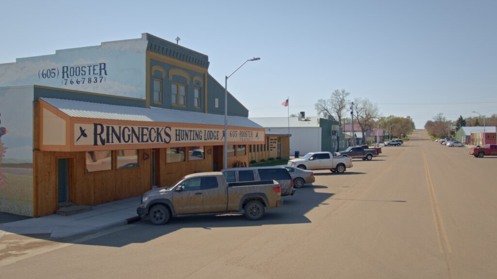 Vehicles parked in front of Ringnecks Lodge on Main Street Presho, SD